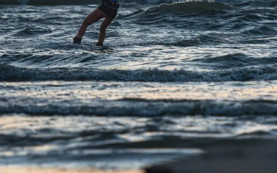 Kitesurfeur dans les vagues au coucher du soleil