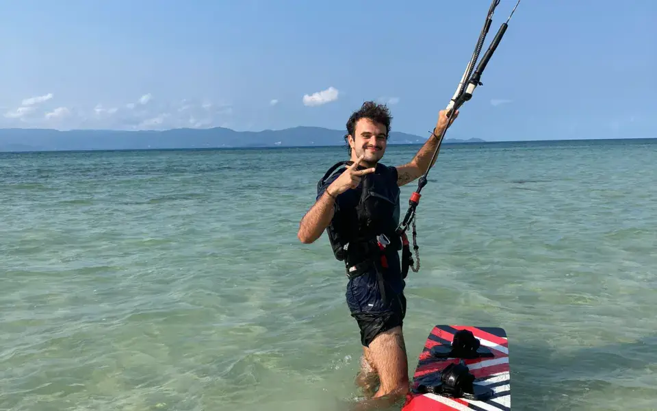 Élève dans l'eau peu profonde avec sa planche et sa barre