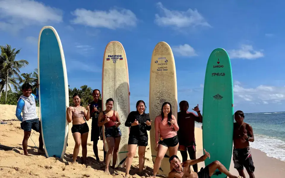 Groupe d'élèves avec leurs planches sur la plage