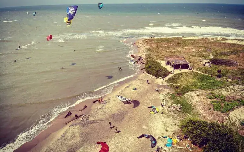Vue aérienne de la plage avec de nombreuses ailes de kitesurf