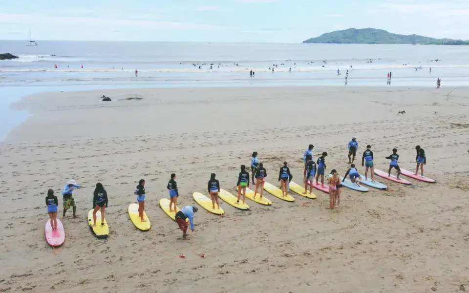 Un groupe d'élèves aligné sur la plage avant le cours