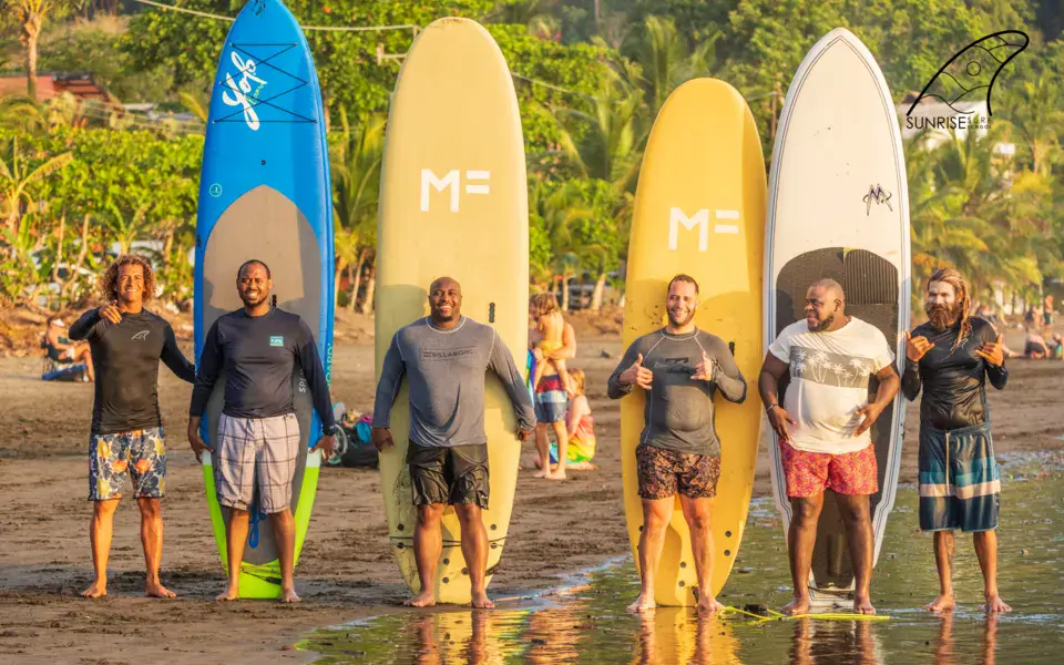Groupe d'élèves avec leurs planches sur la plage
