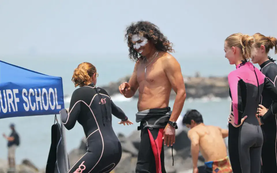 Tente de l'école de surf sur la plage, avec élèves et moniteur