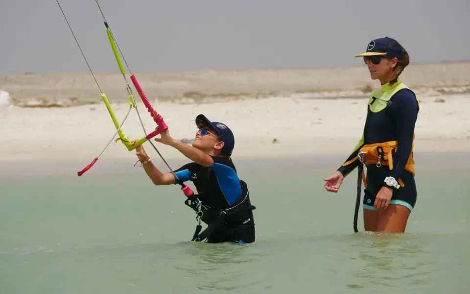 Une monitrice et une élève dans l'eau avec le kite