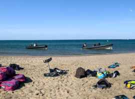 Matériel de l'école sur la plage, bateaux au mouillage