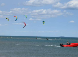 Cours de kitesurf en mer, bateau d'assistance à proximité