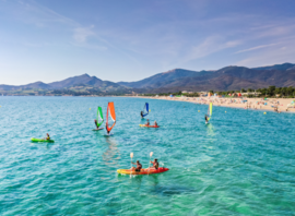 Planches à voile et kayaks devant la plage