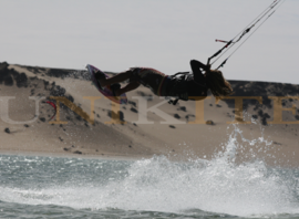 Saut en kitesurf devant les dunes