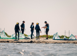 Groupe d'élèves et ailes sur la plage du spot école