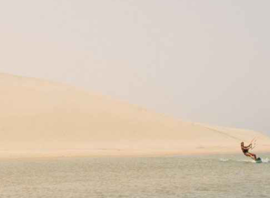 Kiteur isolé au pied des dunes