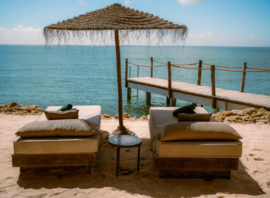 La plage privée, ses transats et le parasol de paille