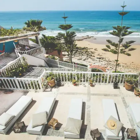 La terrasse et les transats au-dessus de la plage