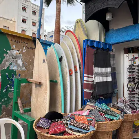 Planches et textile en vitrine sur le trottoir