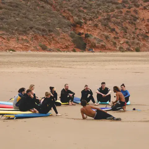 Cours de surf sur la plage, au pied de la falaise