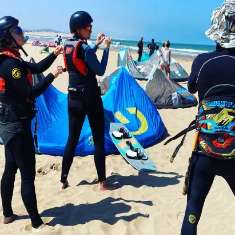 Cours de kitesurf sur la plage, ailes gréées au sol