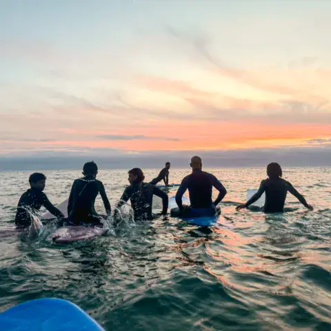 Groupe à l'eau au coucher du soleil