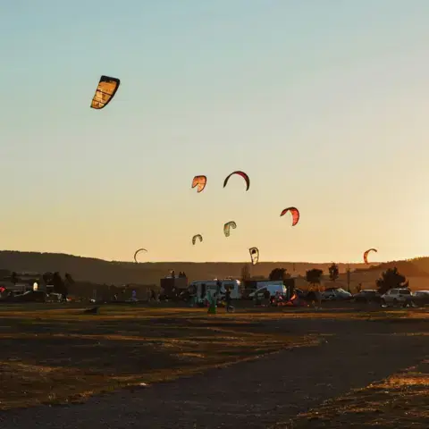 Ailes de kitesurf au-dessus de la baie en fin de journée