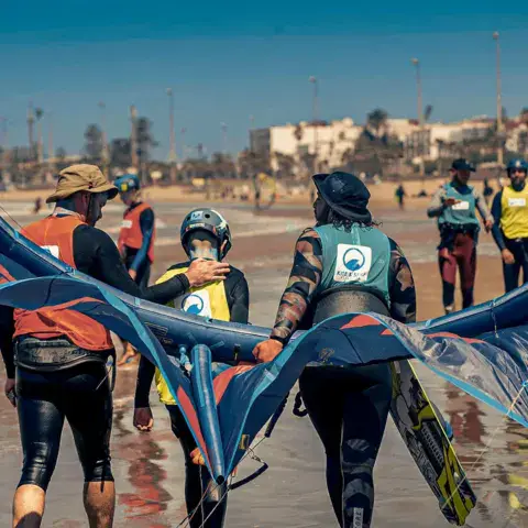 Préparation d'une aile de wing sur la plage, médina en fond