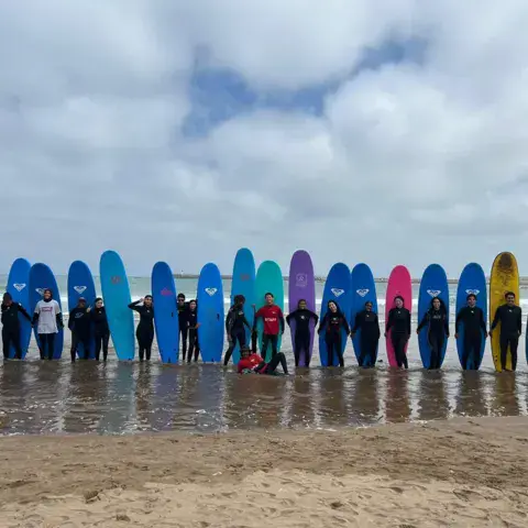 Les planches en mousse alignées sur le sable avant la session