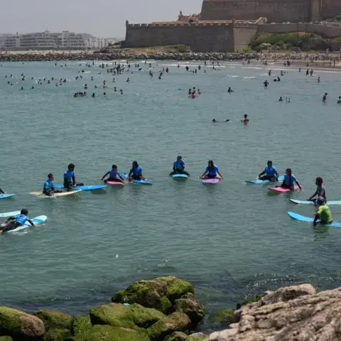 Session de surf vue large, plage des Oudayas au pied des remparts