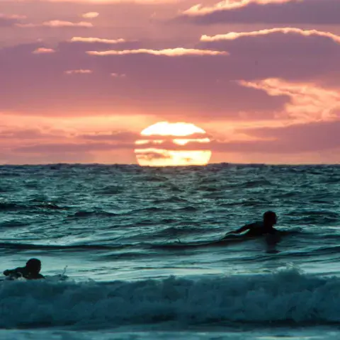 Session de surf au coucher du soleil devant le resort