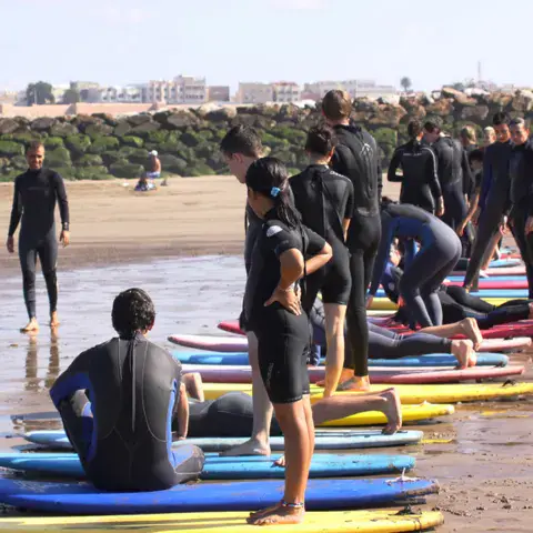 Cours collectif sur le sable, la plage de Rabat et la médina de Salé en arrière-plan