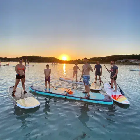 Groupe de paddle au coucher du soleil