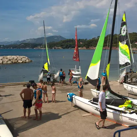 Dériveurs et catamarans sur la plage du club
