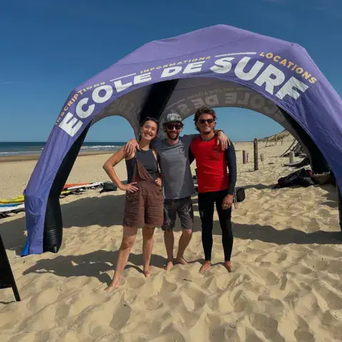 Équipe de l'école devant son stand sur la plage de la Bouverie