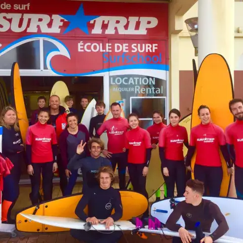 L'équipe de l'école de surf devant la boutique