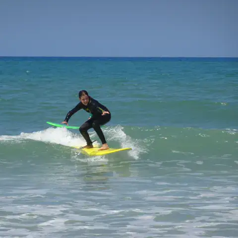 Surfeur sur une vague devant la plage de la Pantoufle