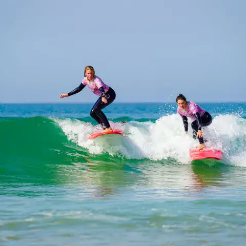 Élève en cours de surf sur une vague
