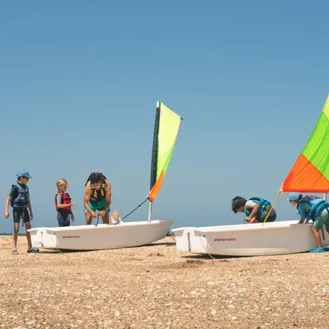 Initiation à la voile sur des dériveurs échoués sur la plage