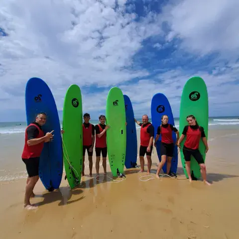 Groupe d'élèves avec leurs planches sur la plage de Vieux-Boucau