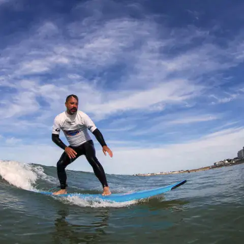 Élève sur une vague pendant un cours de surf
