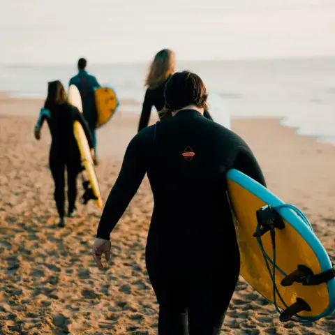 Élèves avec leurs planches sur la plage