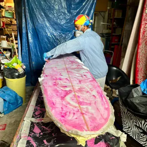 Réparation d'une planche de surf à l'atelier