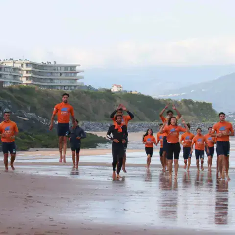 Échauffement en groupe sur la plage avant le cours