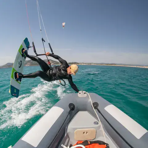 Kitesurfeur en saut depuis le bateau d'assistance
