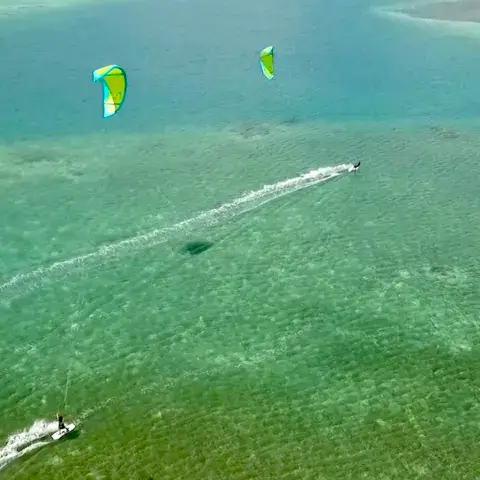 Vue aérienne de kitesurfeurs sur un plan d'eau peu profond