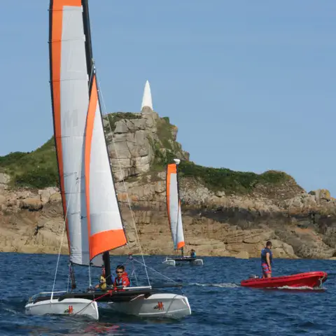 Catamaran devant la côte rocheuse de Port-Blanc
