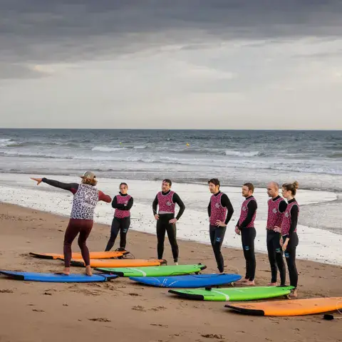Groupe d'élèves et planches alignées sur la plage