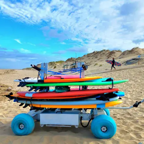 Chariot chargé de planches de surf sur la plage de la Côte Sauvage
