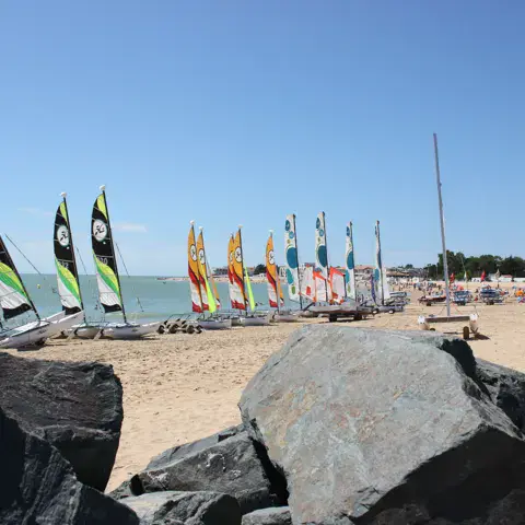 Catamarans sur la plage devant le centre nautique
