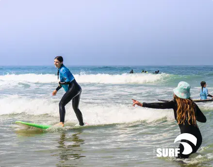 Cours de surf dans l'eau avec une monitrice