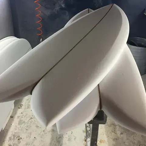 Planches shapées en mousse brute dans l'atelier