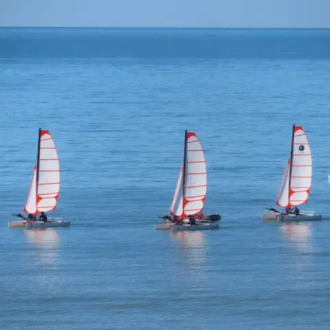 Catamarans à la voile près de la côte