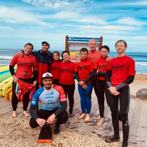 Équipe de l'école de surf Rainbow sur la plage de la Petite Chambre d'Amour