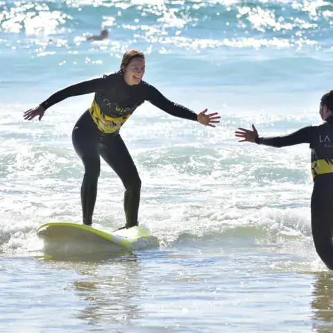 Cours de surf avec un moniteur dans les vagues