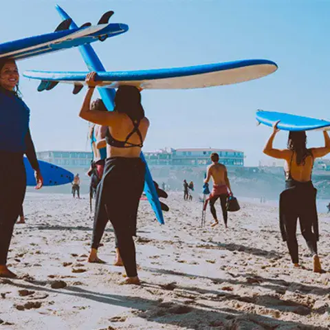 Planches de surf et de paddle portées sur la plage